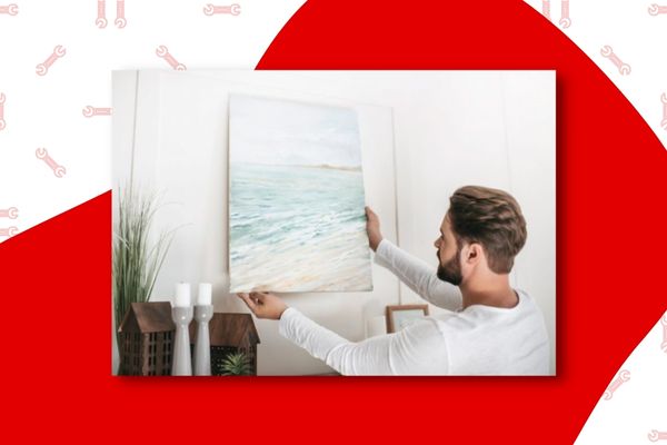 image of man hanging an ocean themed picture