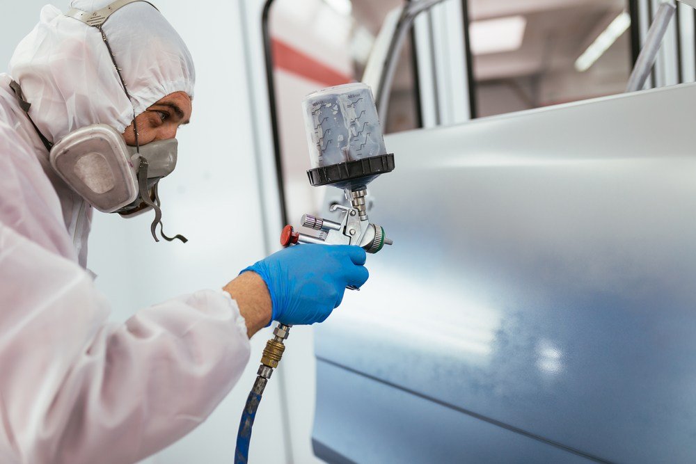 image of mechanic painting car with sprayer