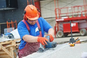 image of construction worker in organge hard hat using a track saw