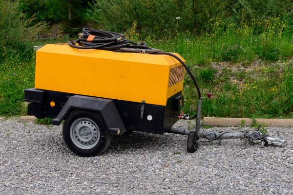 a yellow portable air compressor trailer