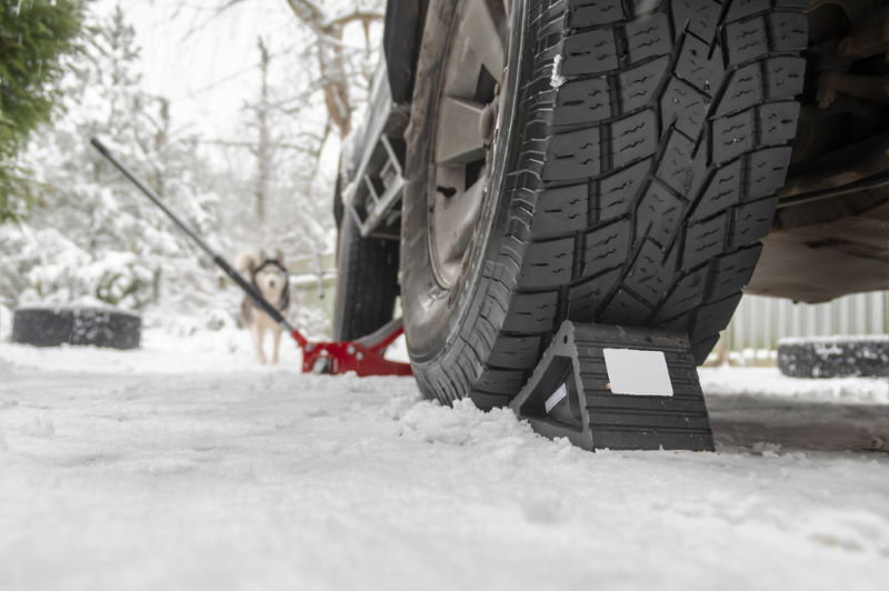 rubber wheel chock securing car in snow